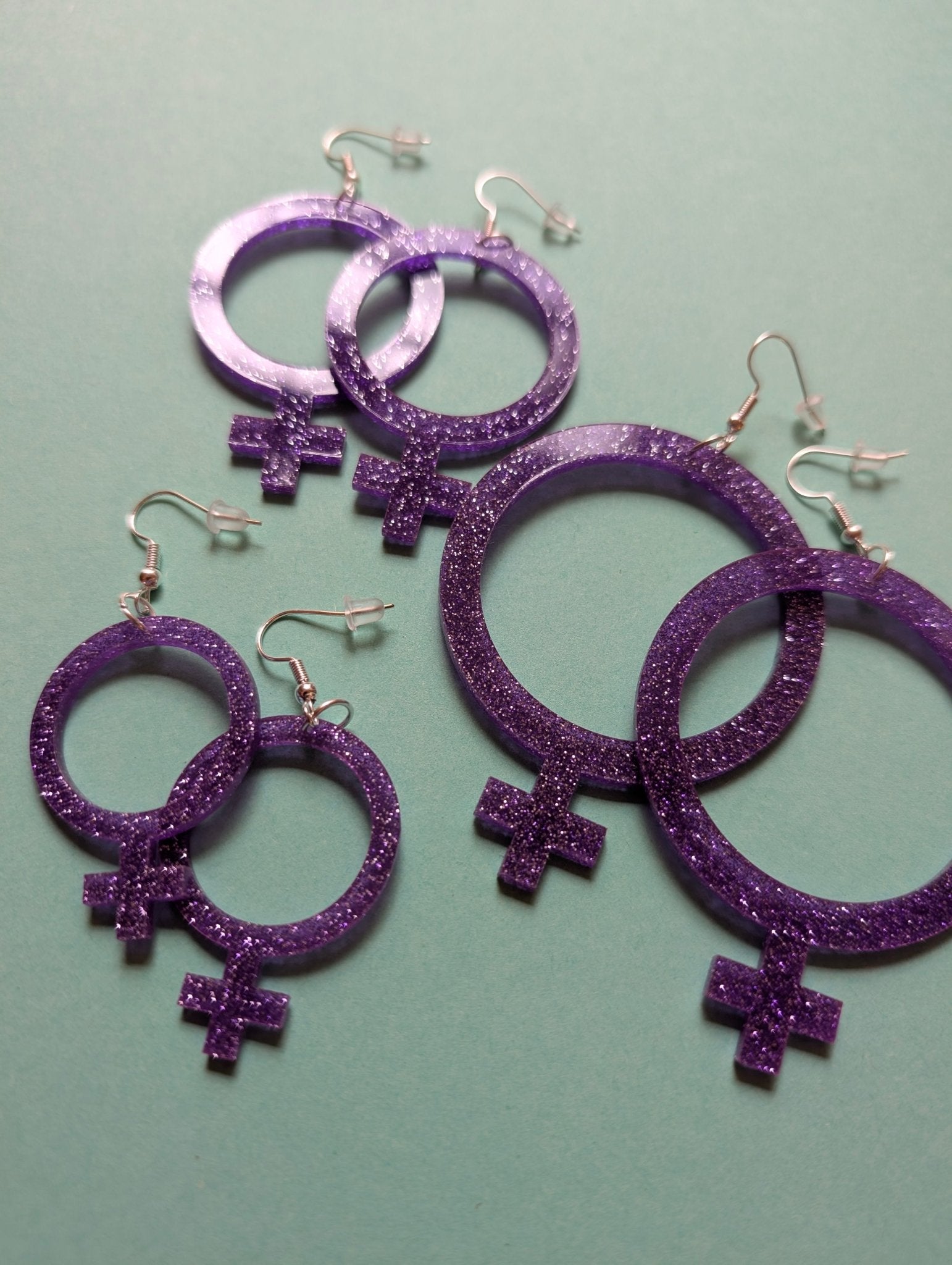 Feministörhängen glitterlila - Rino Design Sthlm